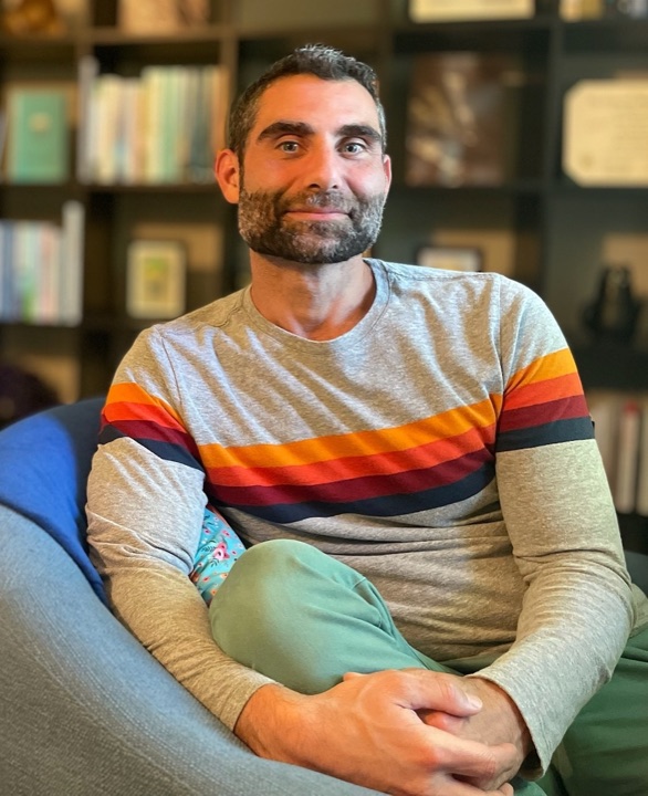 Max Littman seated in front of bookshelves